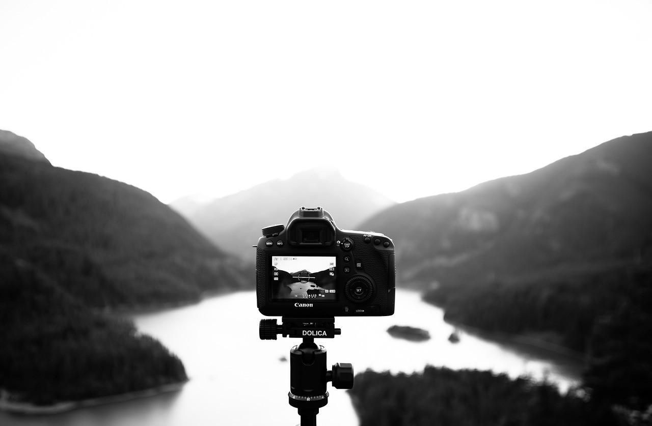 cámara de un curso de fotografía en trípode frente a paisaje montañoso